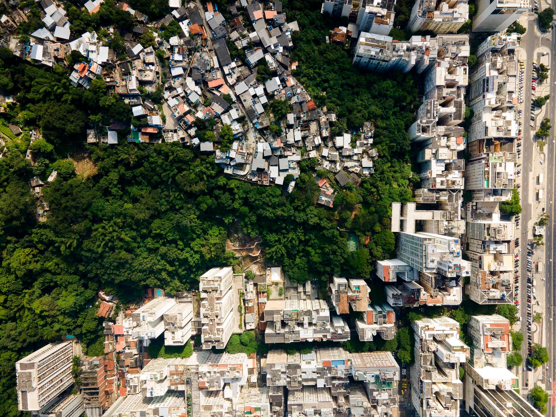 Dense favela pressed against high-rise apartments in Copacabana, Rio de Janeiro, showing spatial inequality.