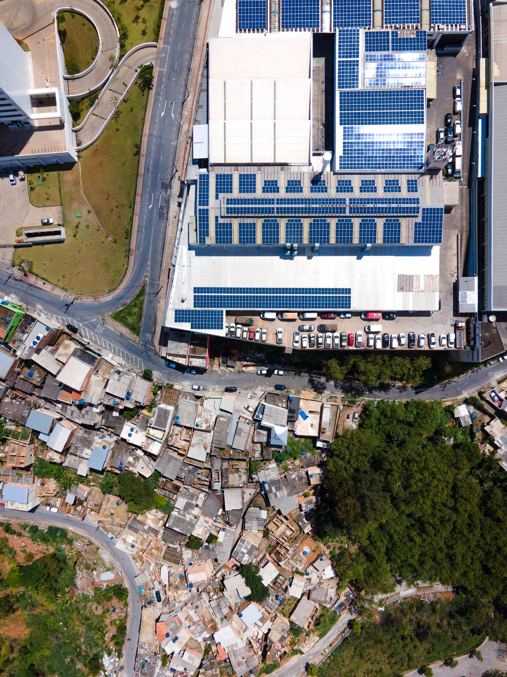 A Porsche dealership in Belo Horizonte sits directly next to a favela, symbolizing extreme economic contrasts.