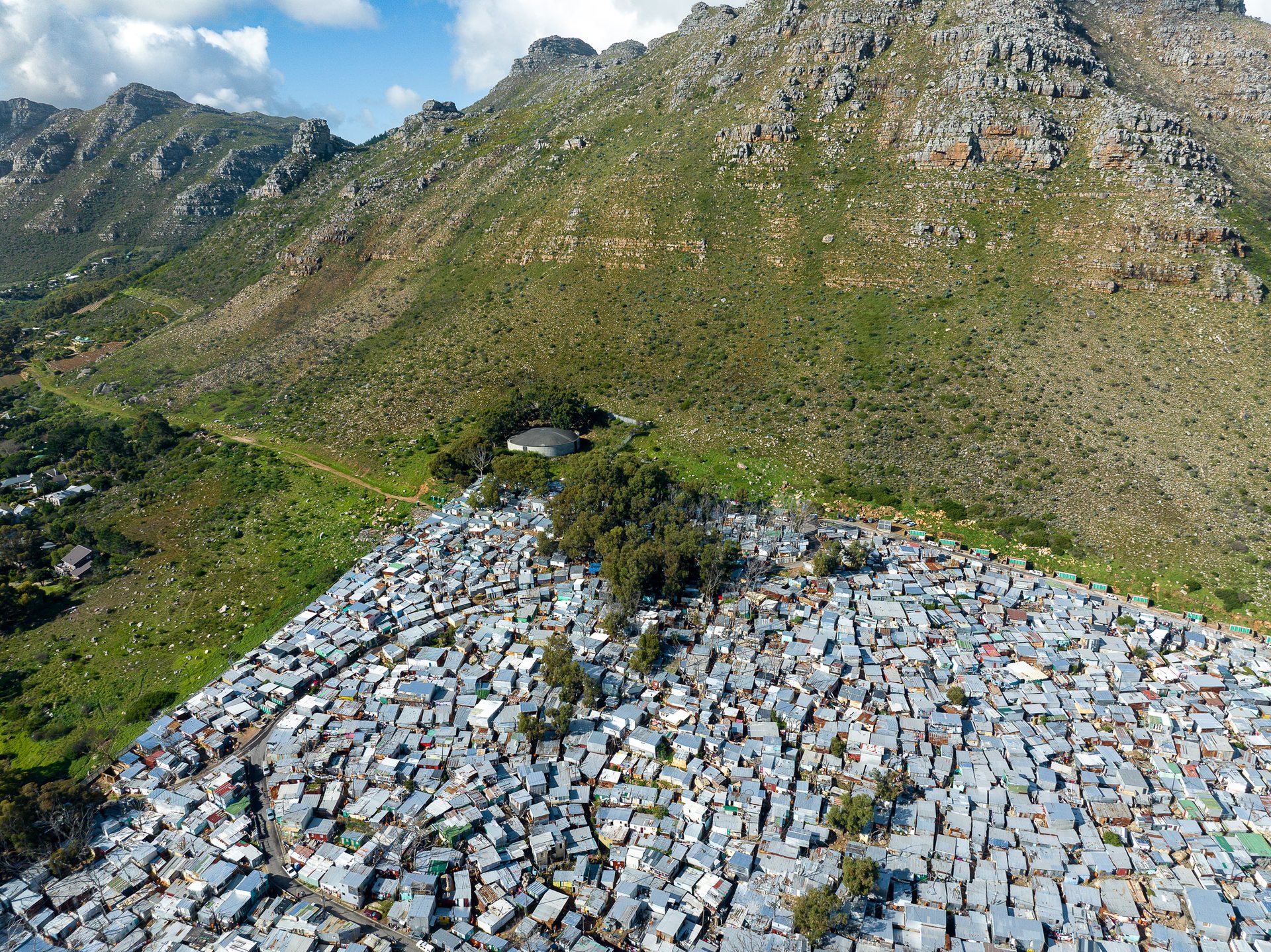 Contrasting zinc shacks with winter's green slopes on Table Mountain National Park.