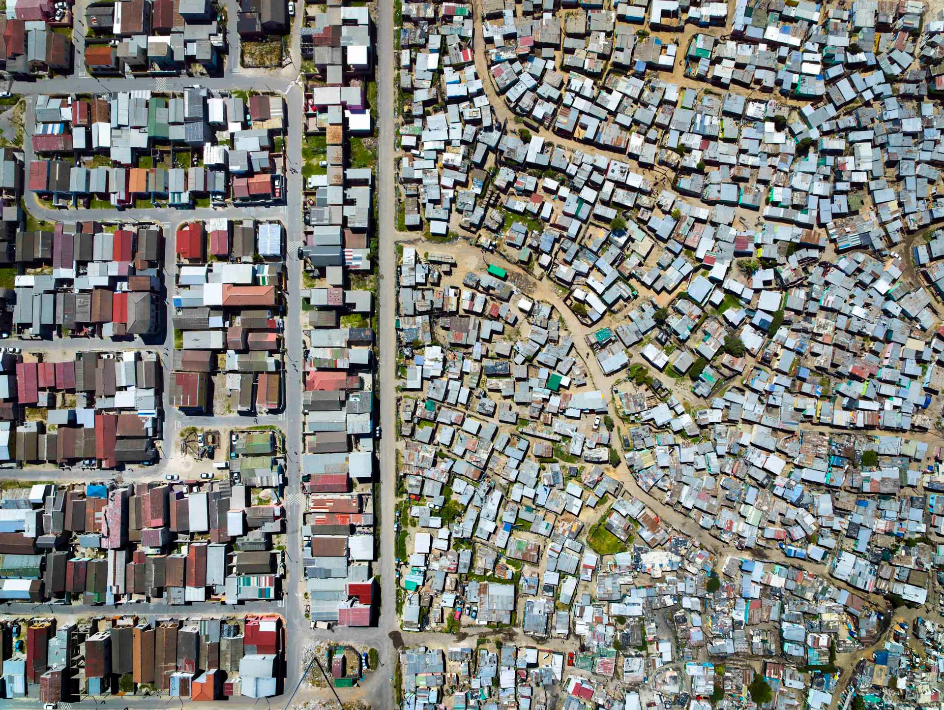Squalid conditions for thousands who live in the shacks of Nomzamo, with an interesting walled "Access Road" along the creek between gated