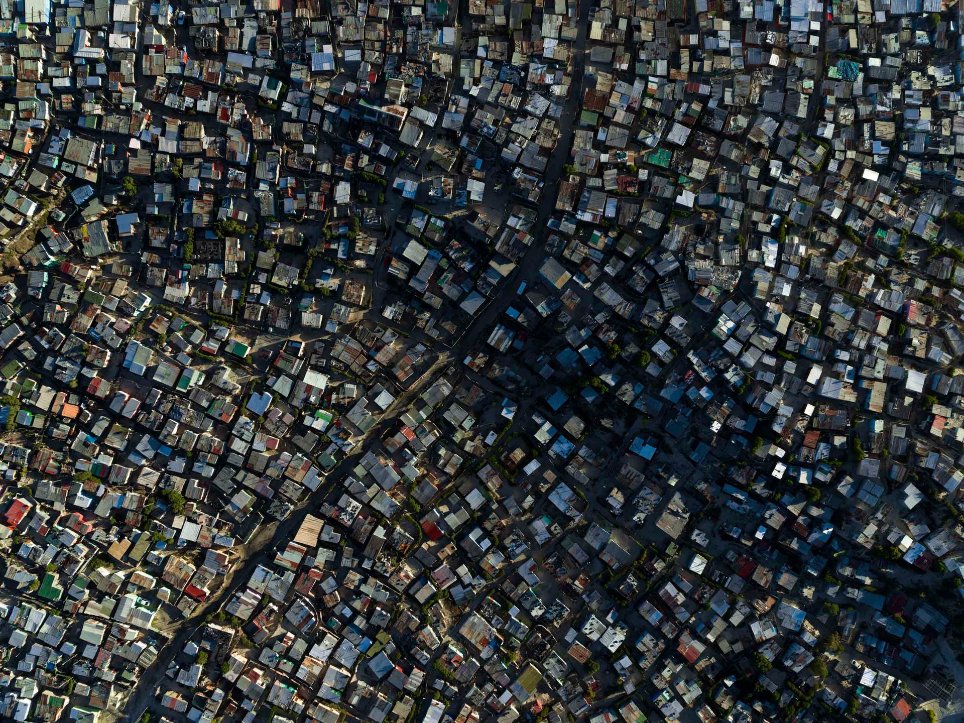 The organic tangle of roads and dwellings disappears into the shadows in Khayelitsha, near Cape Town.