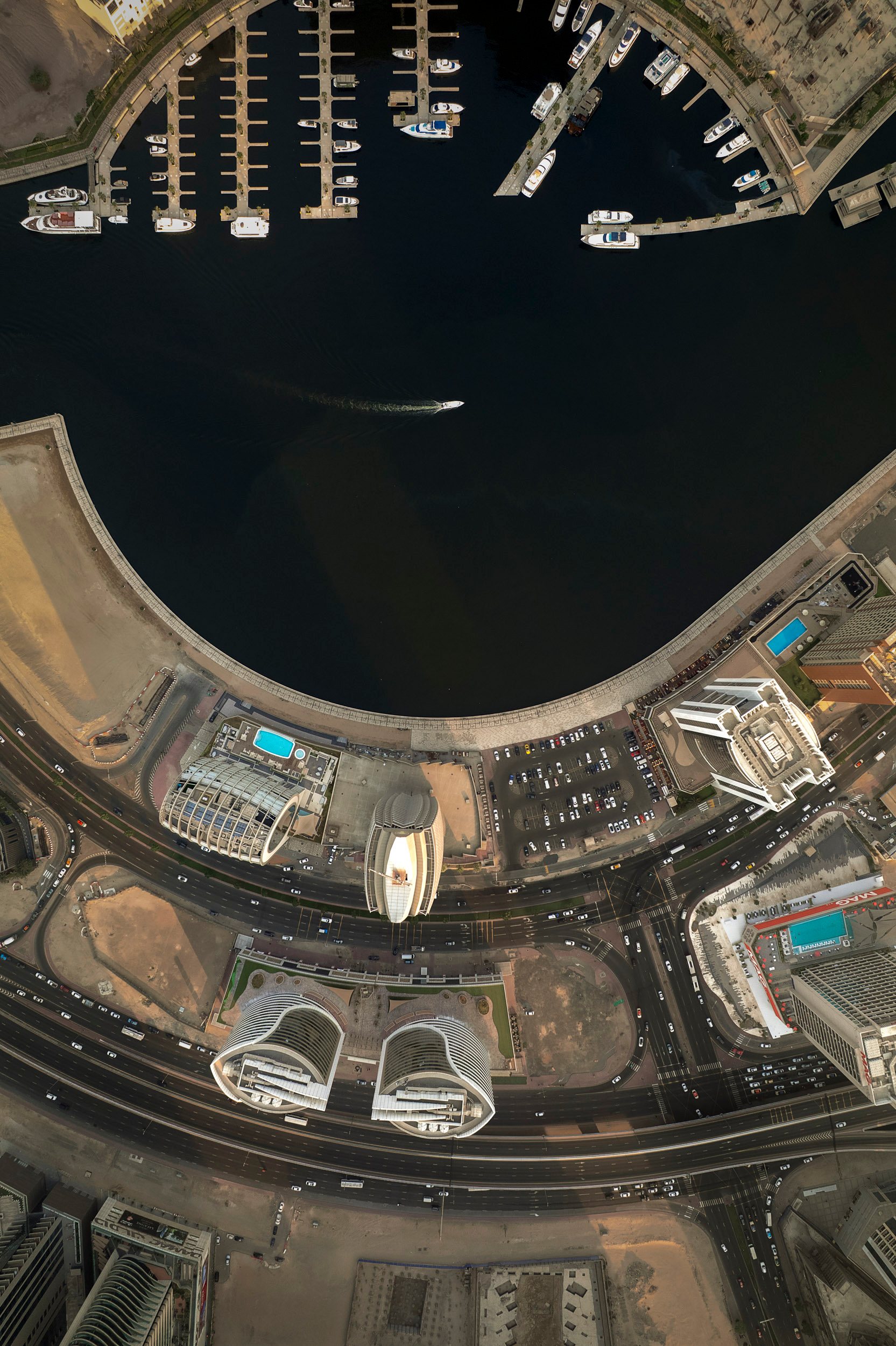 Towers line the Dubai Water Canal, a man-made channel cut through the city in 2016, as a boat slips past the glass and the waterfront