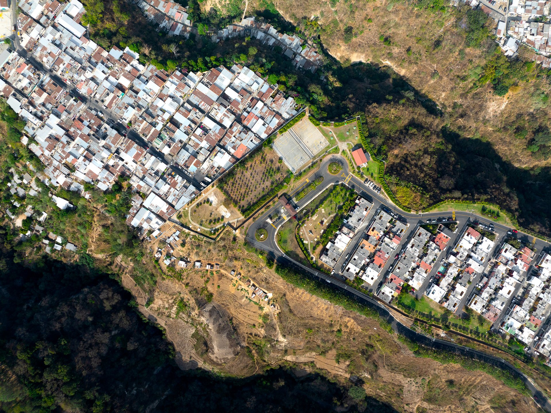 On the top of a ridge in Mixco, two communities sit side by side but are divided by a fence.