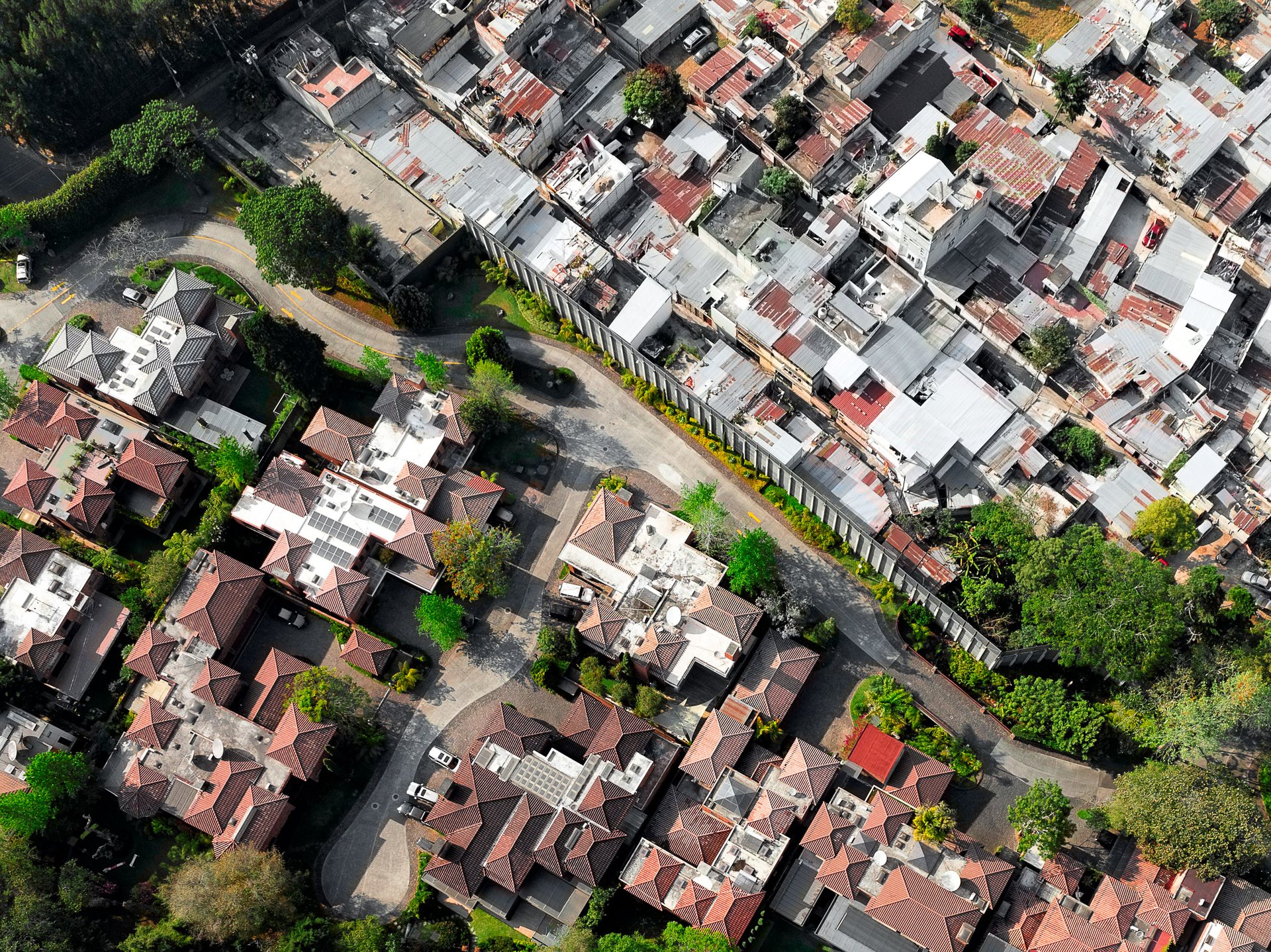A high wall separates the poor from the golf estates in San Isidro, Zone 16.