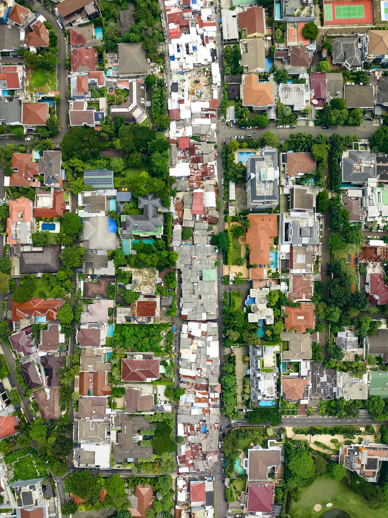 Slums proliferate in a never-used easement terminating in a giant road near Jakarta's central business district.