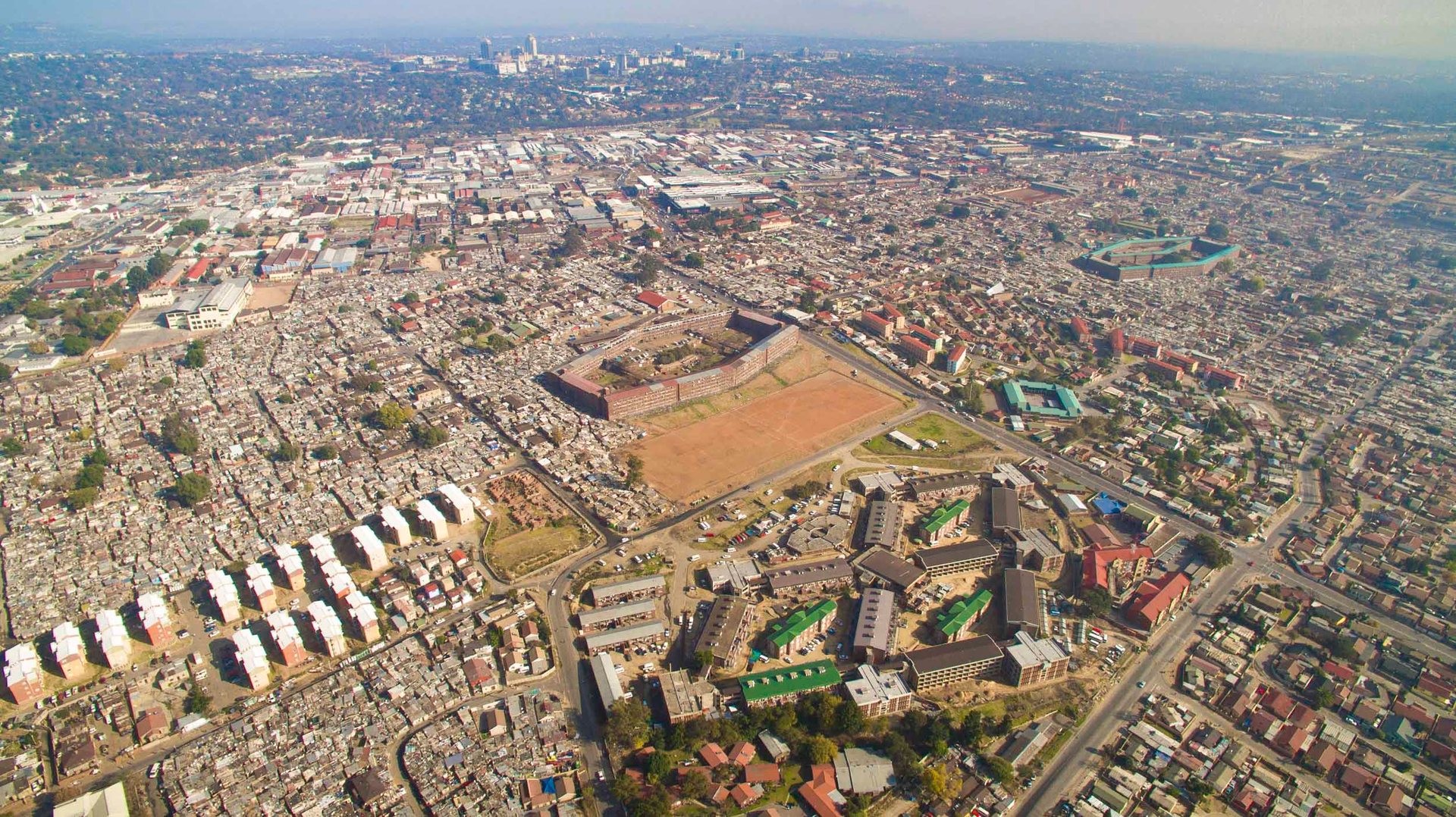 Massive hostels, built to control and house black workers in the early 20th century, still stand in Alexandra, just kilometers from Sandton, "The Richest Square Mile" in Africa.