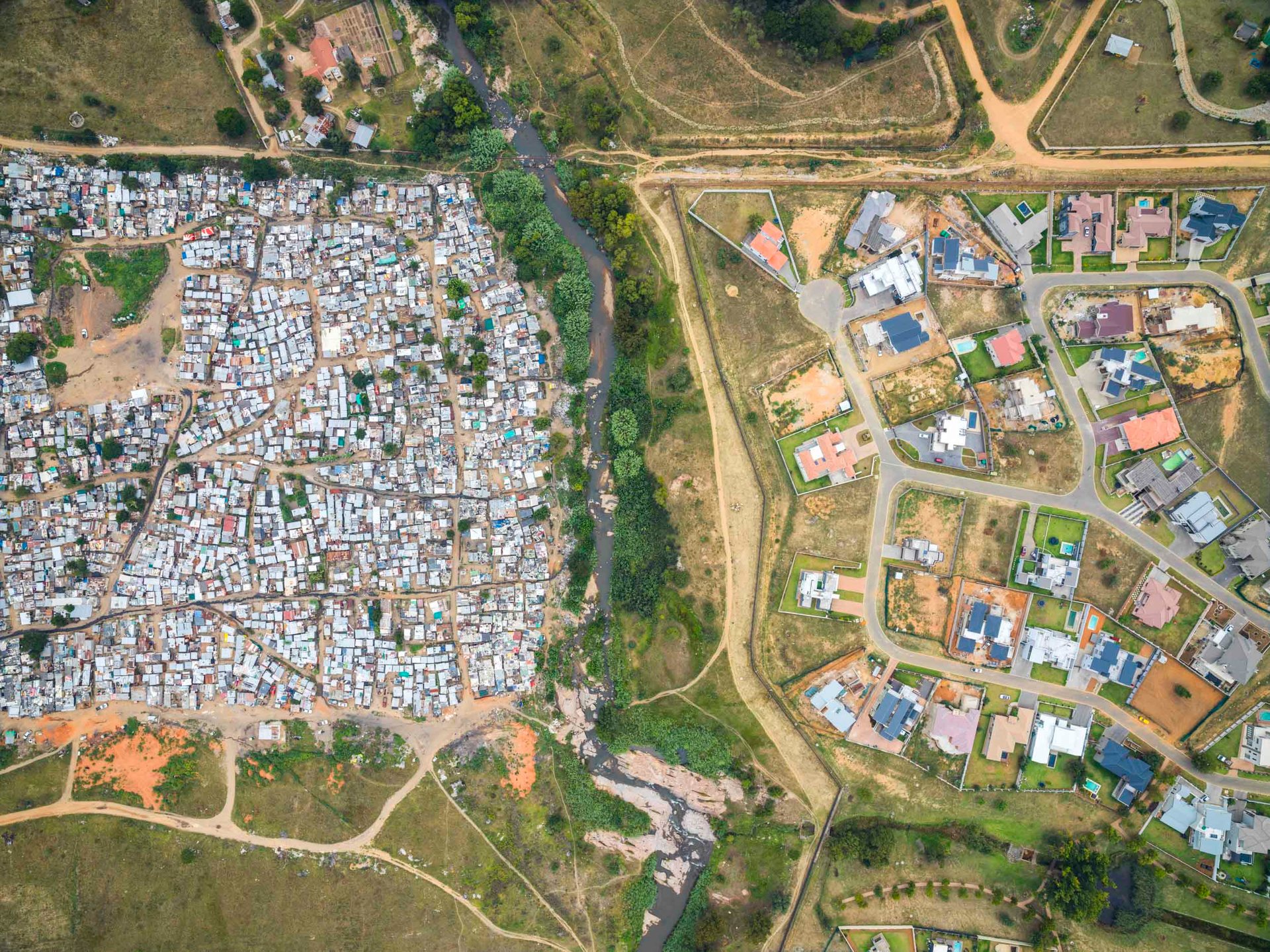 The Klein Jukskei river and its tributaries split this scene, north of Johannesburg, between the informal settlement of Msawawa and the Cedar Creek Estates.