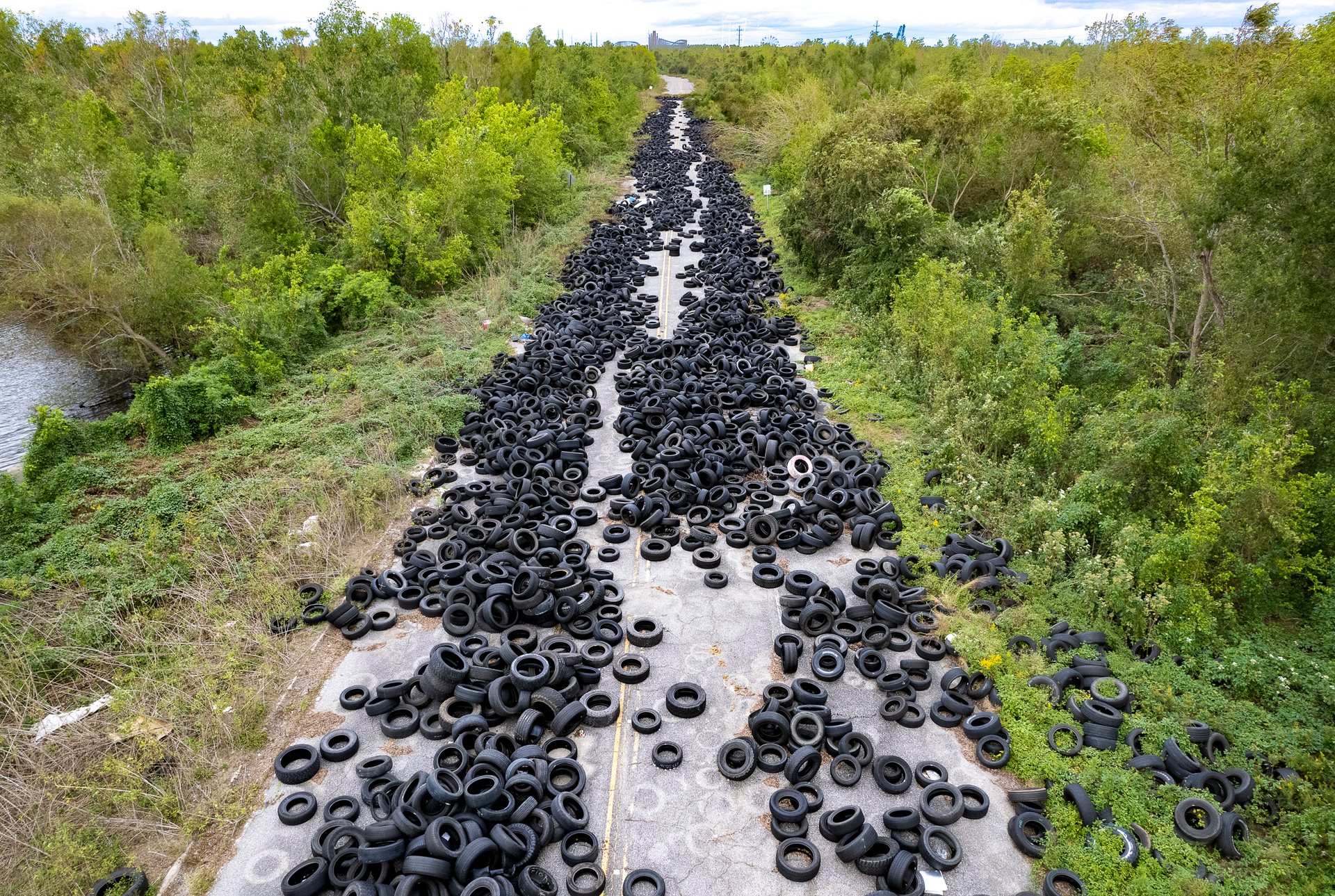 At the interchange of Interstate 10 (I-10) and Michoud Boulevard in New Orleans East, an abandoned service road behind a subdivision has been used for the illegal dumping of thousands of tires.