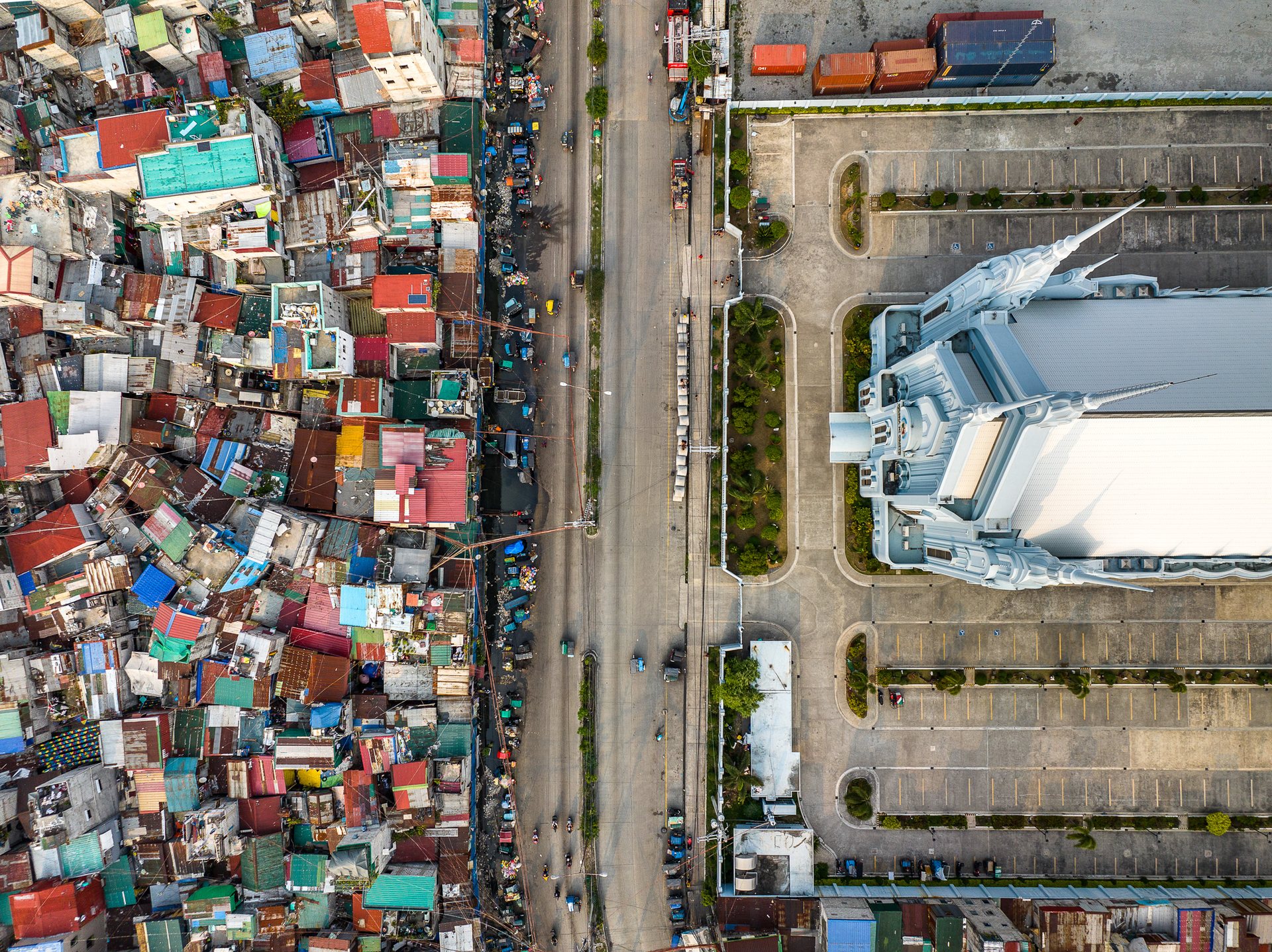 Aerial photo of Iglesia ni Cristo in Manila beside tightly packed informal housing, showing stark inequality.