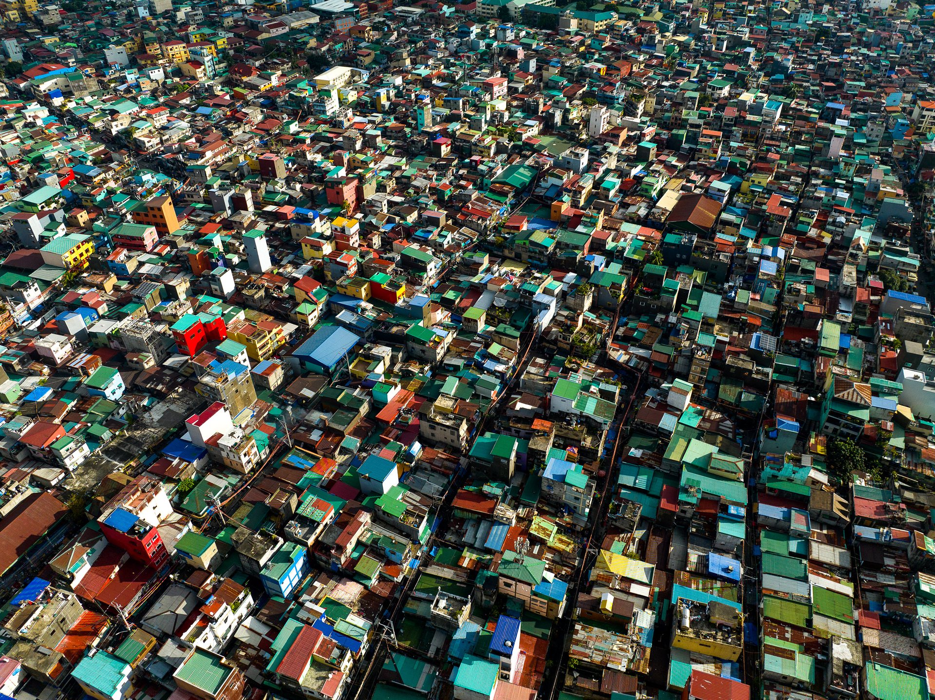 Top-down view of dense rooftops in Pembo, Manila, showing high population density and housing compression.