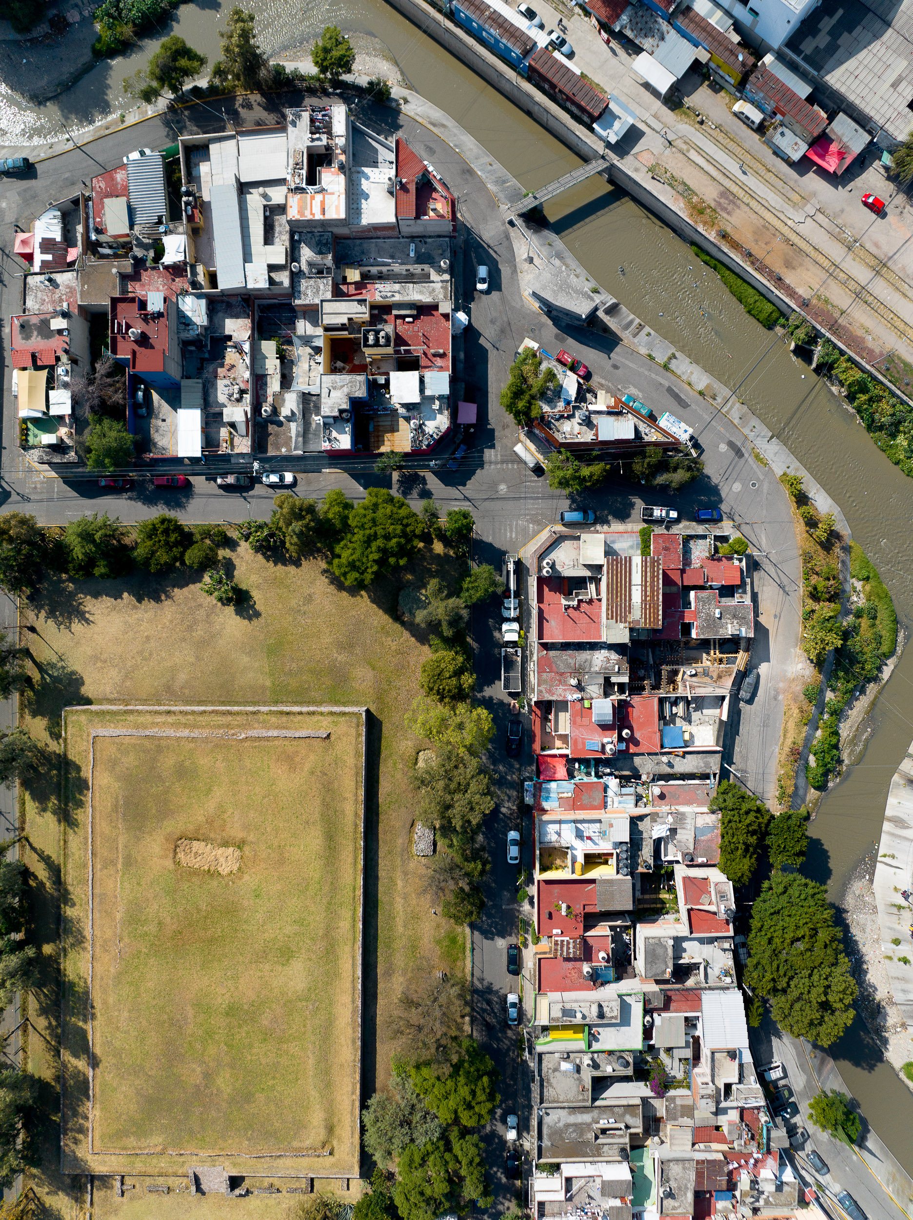 The El Conde pyramid, a Mesoamerican heritage site, sits across the river from a collection of train cars which house dozens of families in Naucalpan, in the Mexico City metro region.