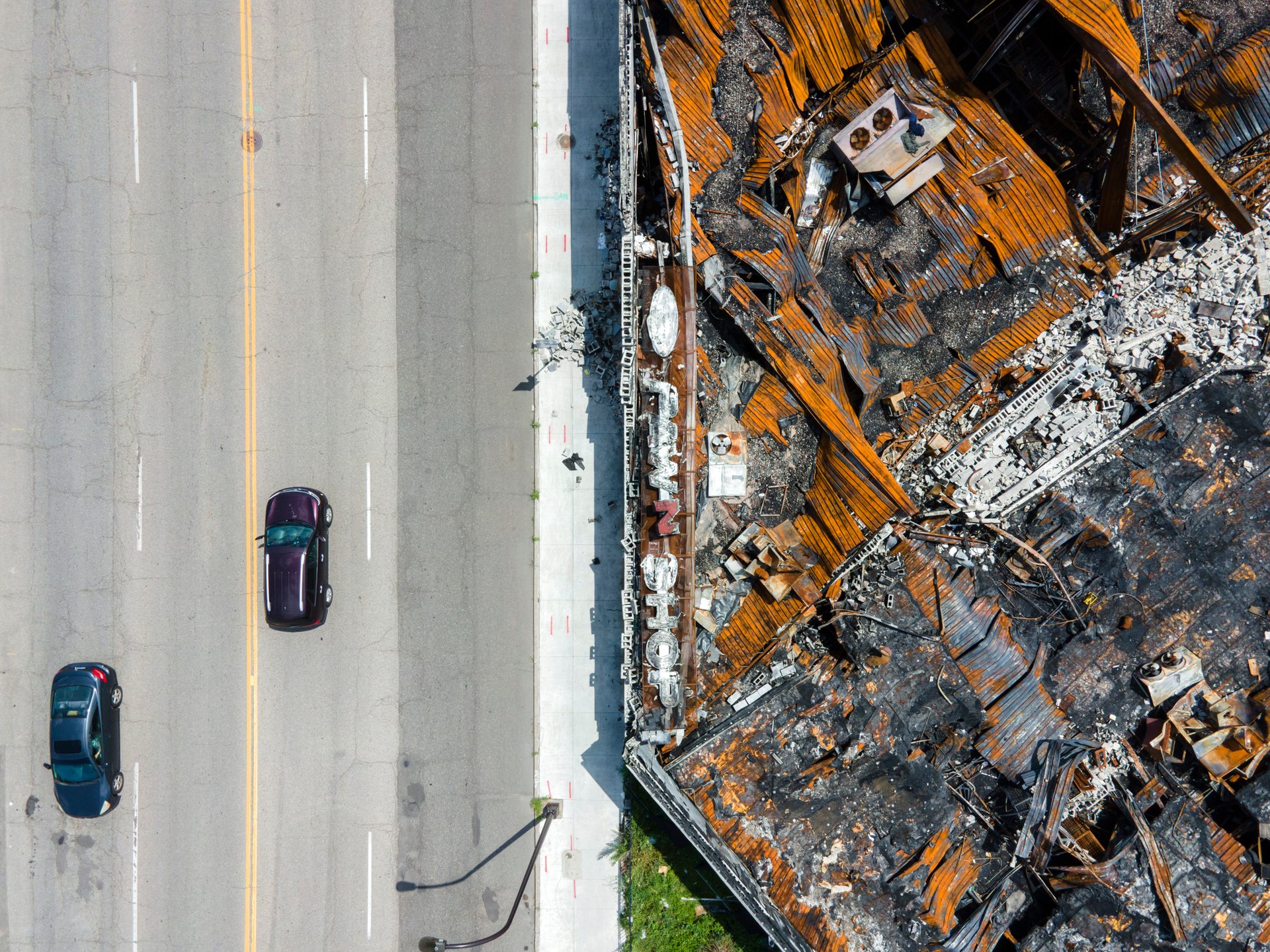 Vehicles drive by a pawn shop gutted in the unrest following the murder of George Floyd.