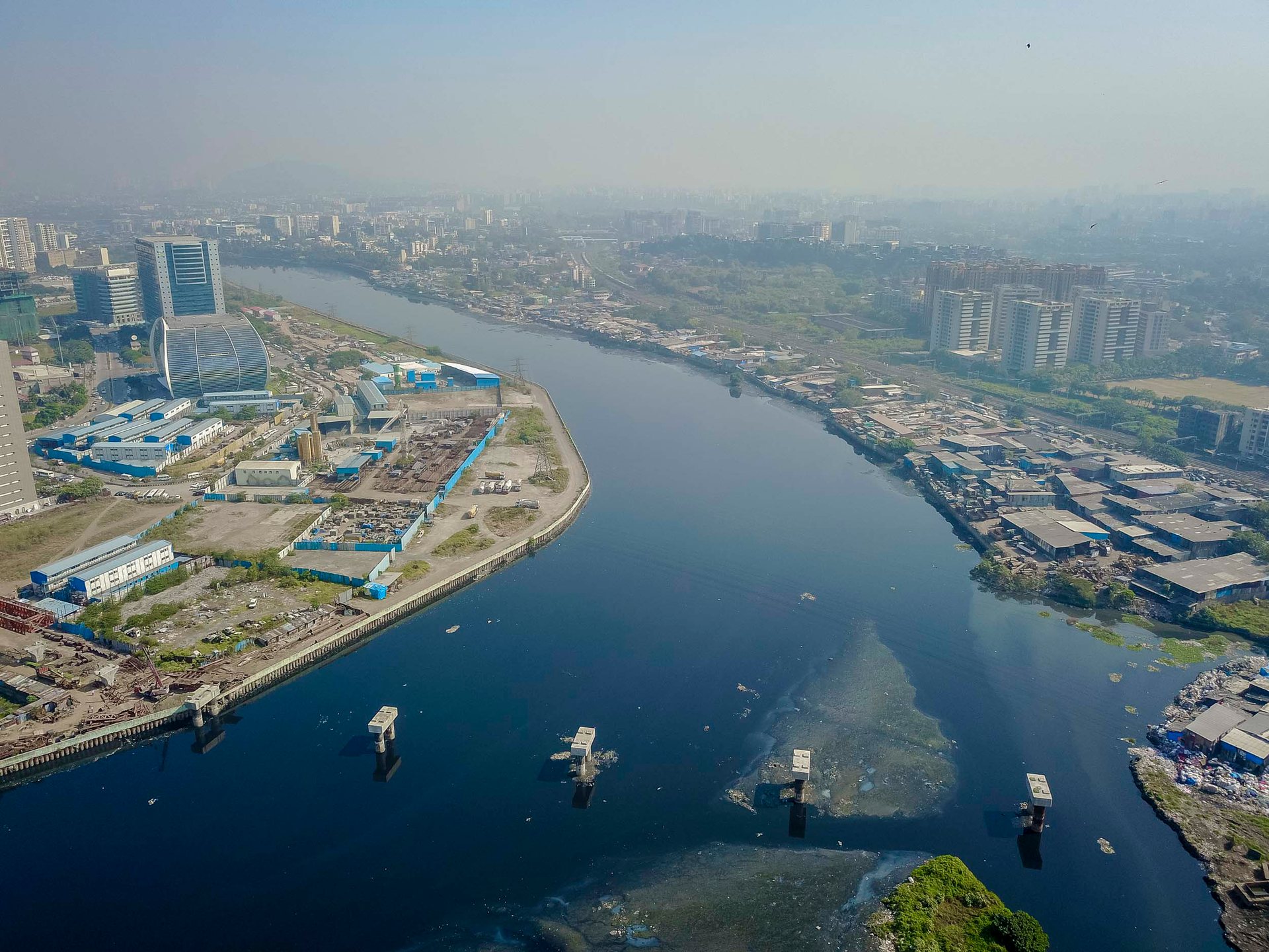 Aerial photo of Bandra Kurla bridges crossing the Mithi River, linking informal settlements to elite business districts.