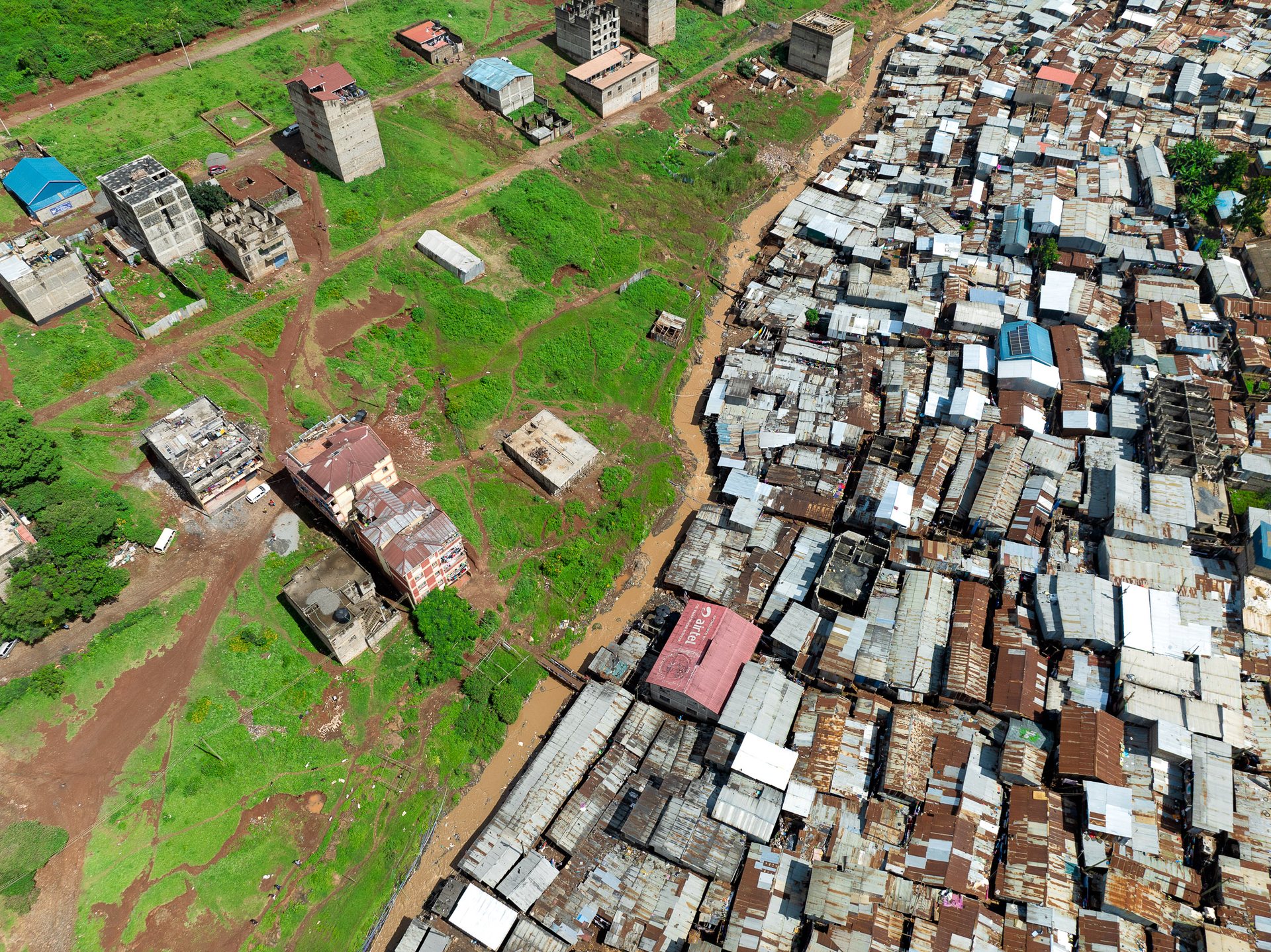 Drone shot showing Nairobi’s urban inequality with well-spaced villas giving way to unplanned settlements.