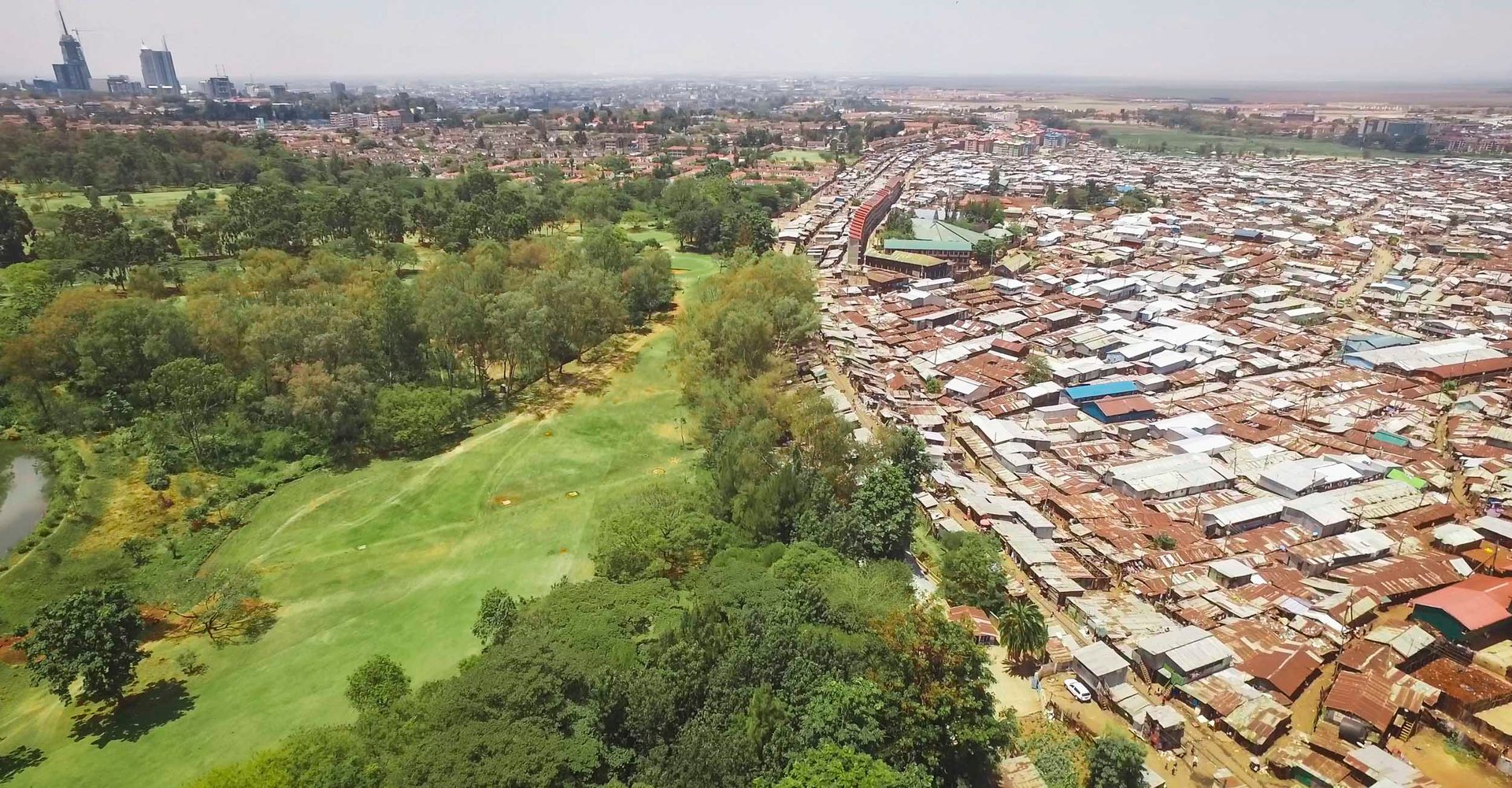 Drone view of Nairobi public park meeting the edge of Kibera slum.