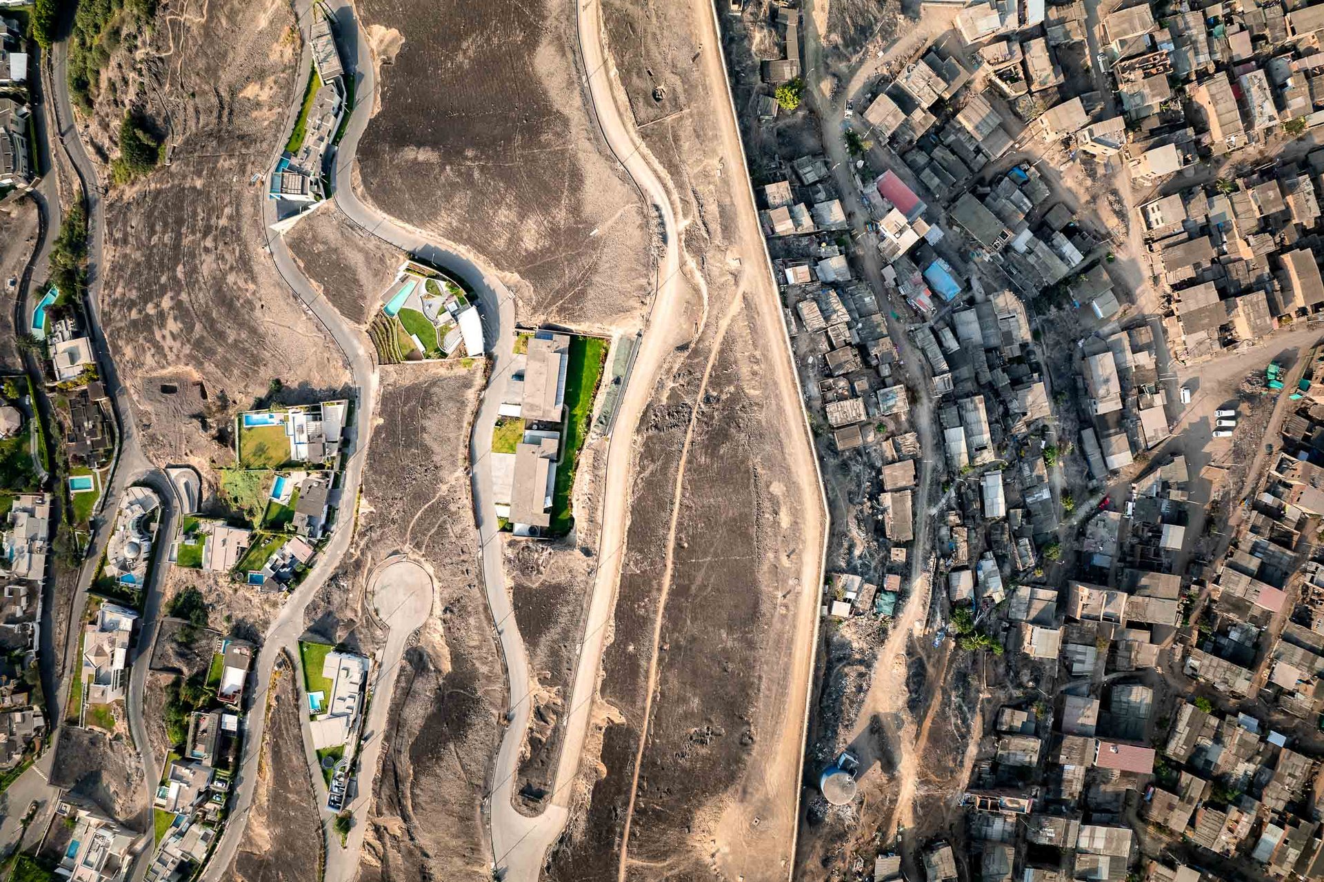 Aerial view of Lima's Wall of Shame separating wealthy gated homes from informal settlements.