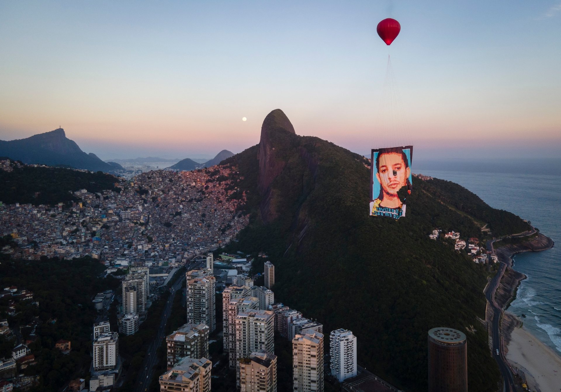 Balloon carrying a memorial portrait floats above Rocinha favela in Rio, part of a local mourning ritual for the Rocinha favela.