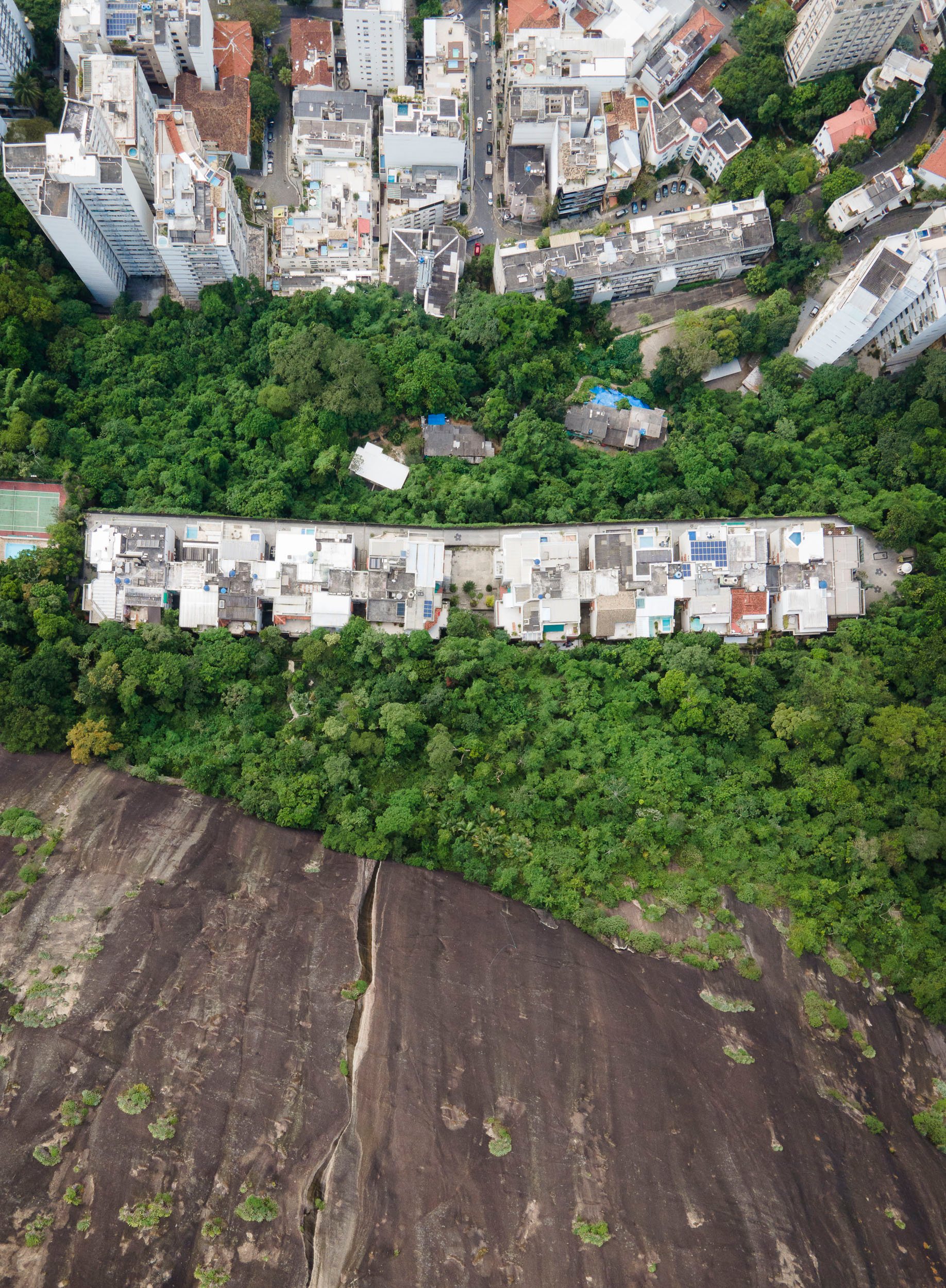 Top-down image of a quilombo settlement surrounded by forest and luxury housing in Rio’s upscale Lagoa neighborhood.