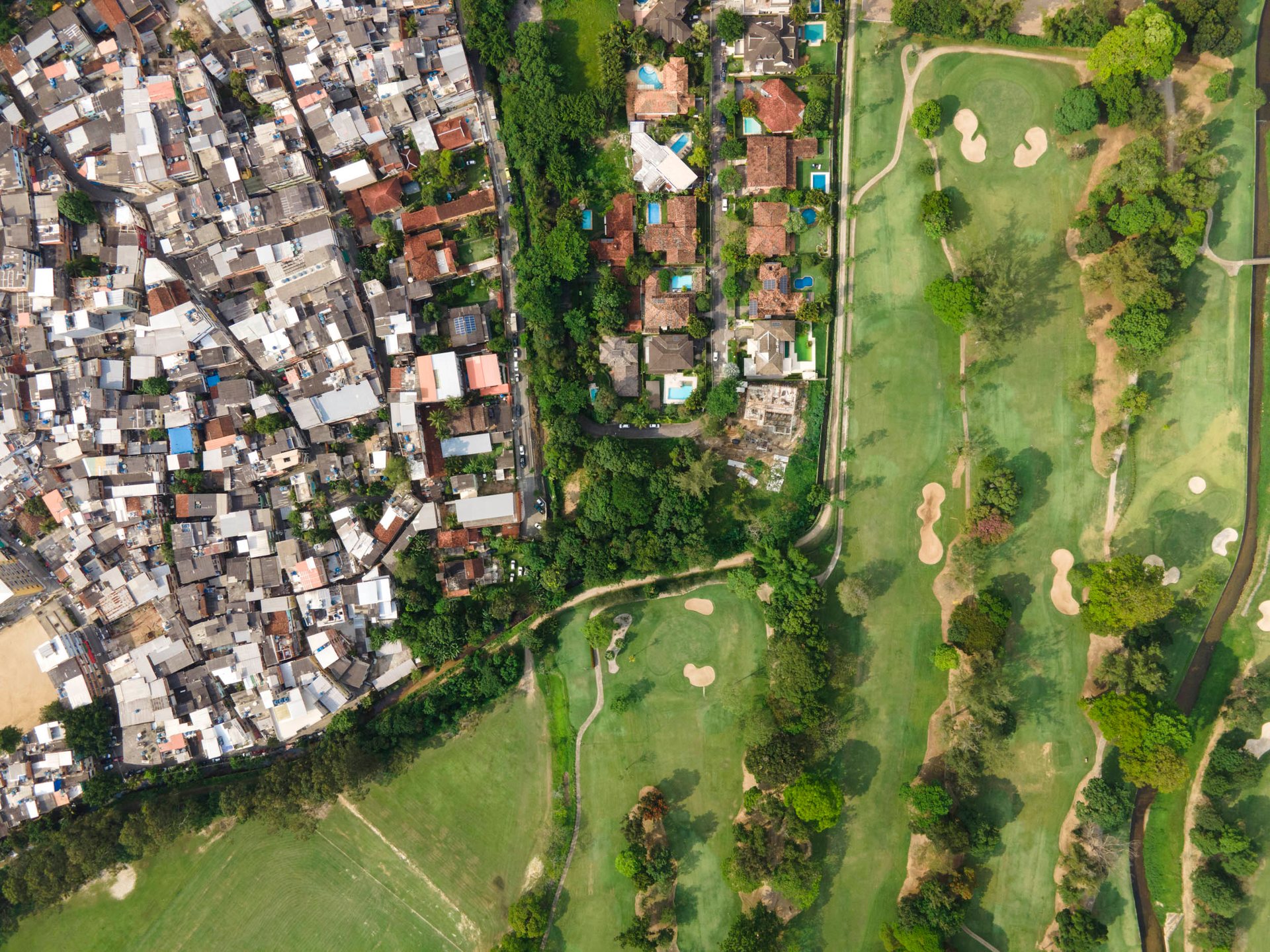 Drone view of Itanhangá Golf Club beside a favela in Rio’s South Zone, revealing stark spatial inequality and green space privilege.
