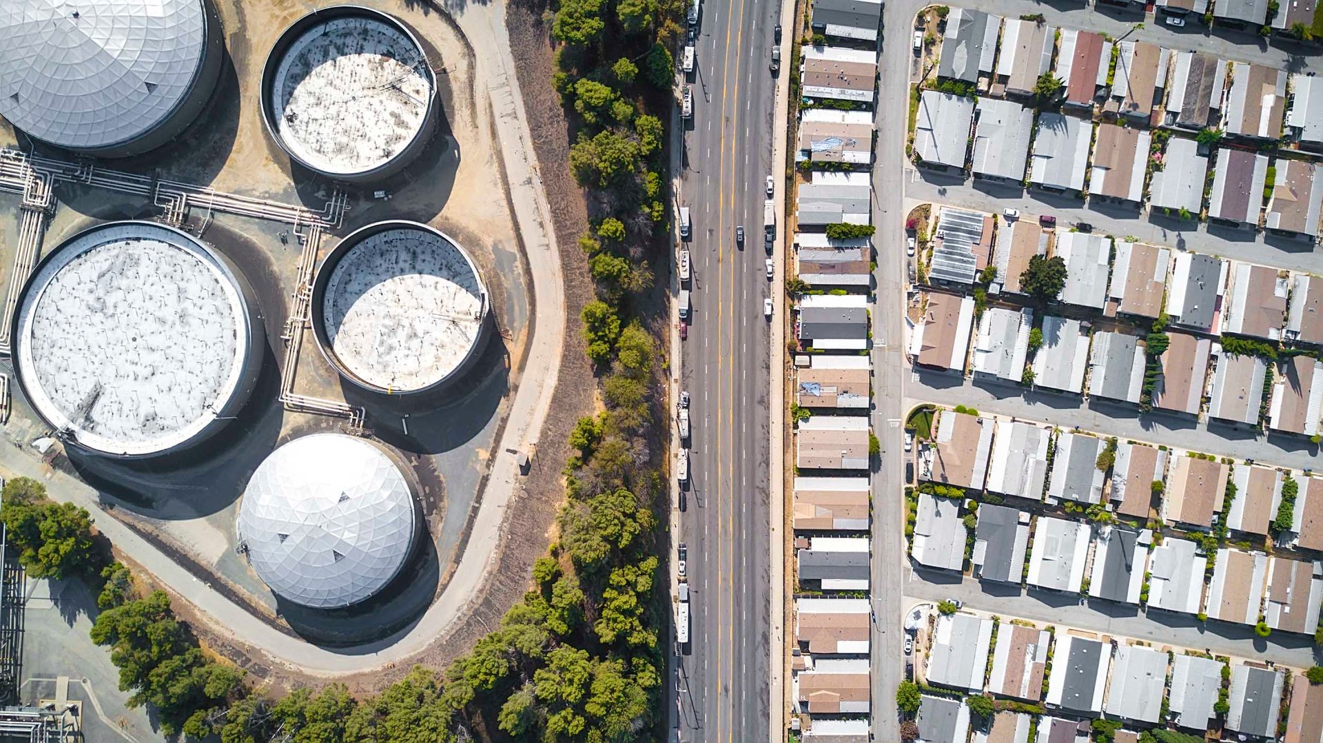 Gas storage tanks sit beside RVs sheltering homeless residents and rows of small single-family homes in Long Beach.