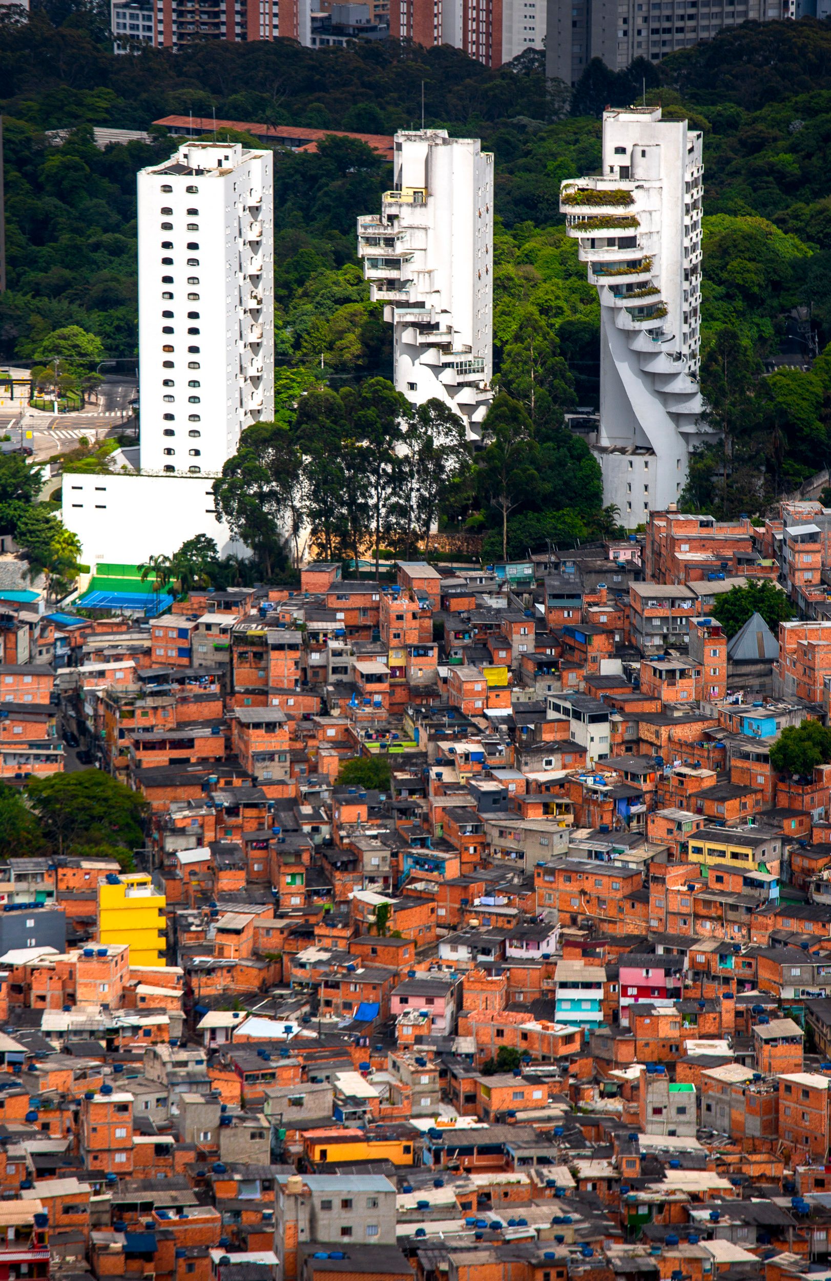 Three towers tower above the favela of Paraisopolis.