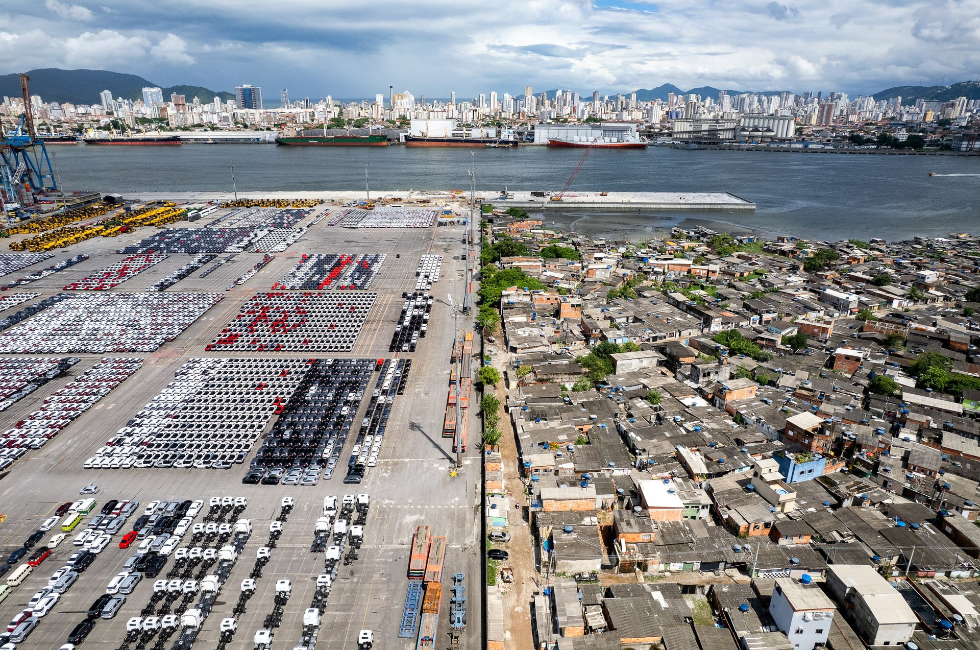 Panoramic shot of Santos port showing rows of containers and cranes, backed by the city’s skyline and hemmed by distant hills.