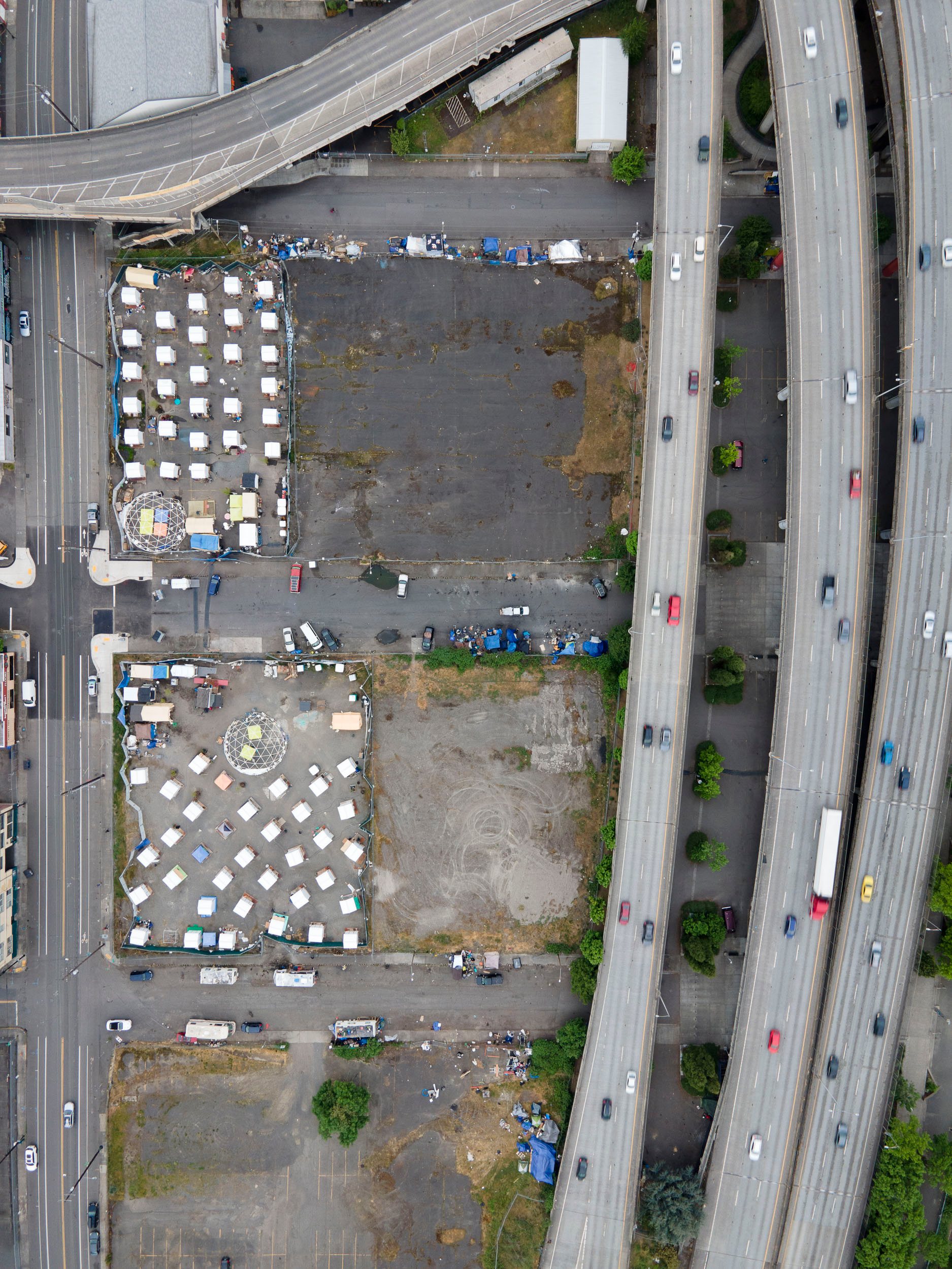 Two of Portland's "C3PO" camps for people experiencing homelessness sit in adjacent lots next to I-5.