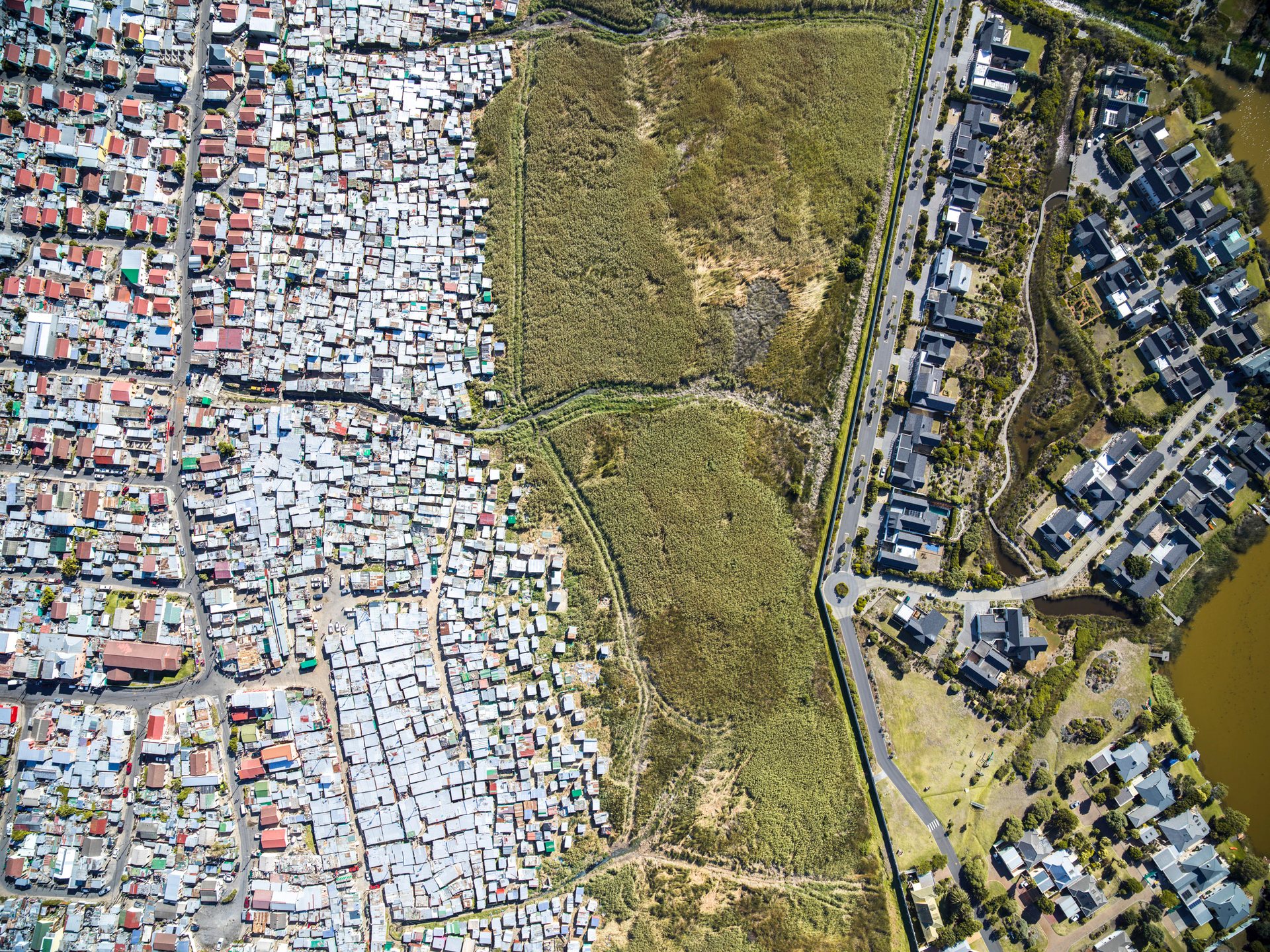 Lake Michelle luxury homes next to Masiphumelele informal settlement in Cape Town, South Africa